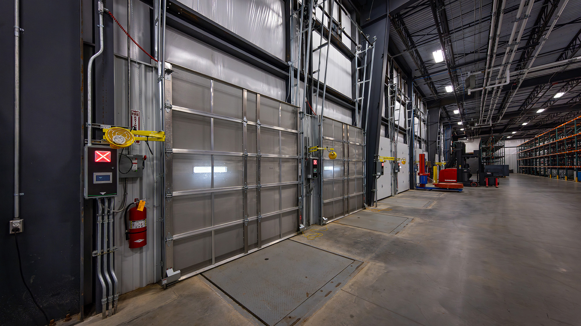 The modern manufacturing facility design for Munzing features safety gates at the mezzanines to allow forklifts to elevate product, and employees to safely retrieve the product once it has been delivered.
